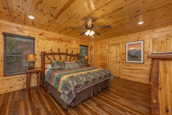 Bedroom with a king bed, two night stands, and two lamps at Pool & a View, a 2 bedroom cabin rental located in Gatlinburg