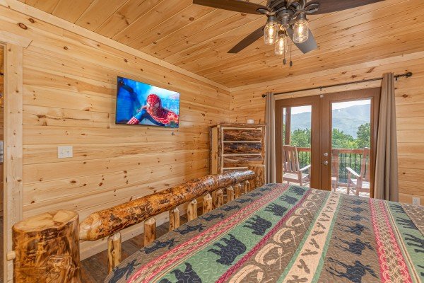 TV and deck entry in bedroom at Twin Peaks, a 5 bedroom cabin rental located in Gatlinburg