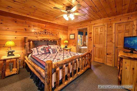 Main level bedroom with king bed and en suite jacuzzi at Tucked Away, a 2 bedroom cabin rental located in Gatlinburg