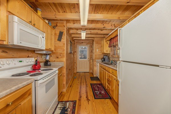 Galley kitchen with white appliances at Wilderness Adventure, a 2 bedroom cabin rental in Pigeon Forge