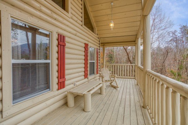 Upper deck with a log bench and log rocker at Bearly in the Mountains, a 5-bedroom cabin rental located in Pigeon Forge