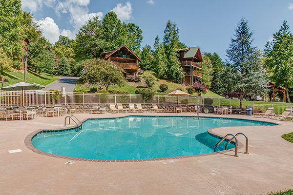 poolside seating and lounge chairs at alpine something blue a 1 bedroom cabin rental located in pigeon forge