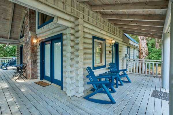blue log rocking chairs on a covered deck at alpine something blue a 1 bedroom cabin rental located in pigeon forge