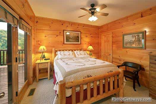 Queen sized bed in bedroom with deck access at Flying with Eagles, a 3-bedroom cabin rental located in Pigeon Forge