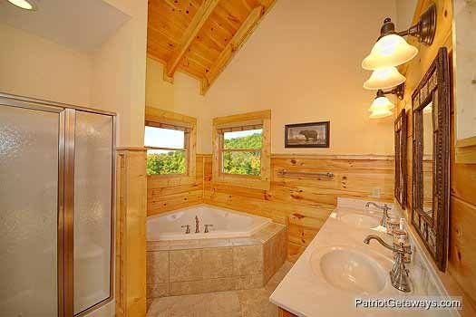 Jacuzzi tub and shower with double sinks in en suite off main floor bedroom at Flying with Eagles, a 3-bedroom cabin rental located in Pigeon Forge