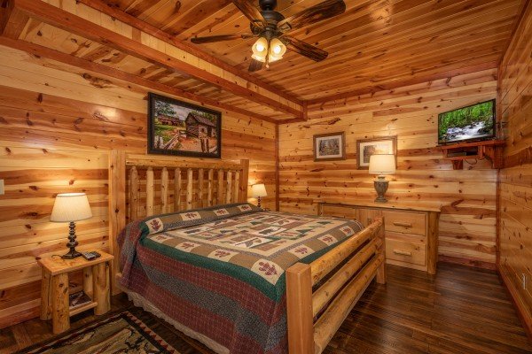 Bedroom with end tables, dresser, and TV at The Pool Palace, a 5 bedroom cabin rental located in Pigeon Forge