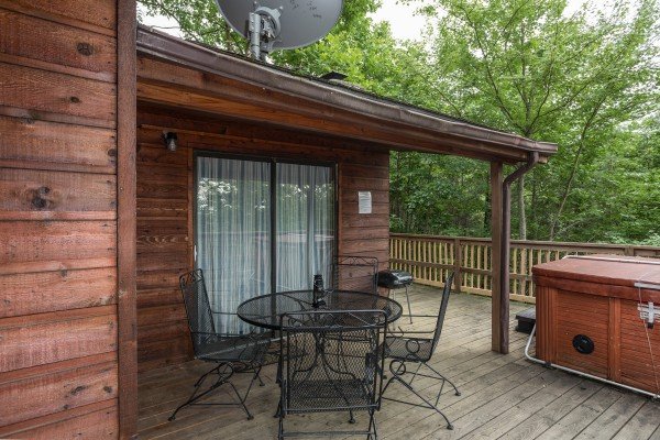Deck with dining table, grill, and hot tub at Peace & Quiet, a 3 bedroom cabin rental located in Pigeon Forge