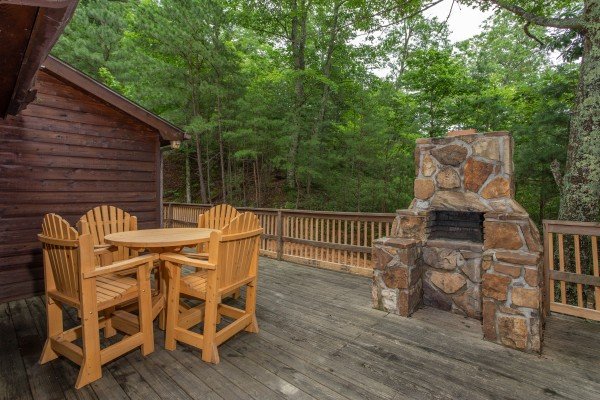 Fireplace and dining table on the deck at Peace & Quiet, a 3 bedroom cabin rental located in Pigeon Forge