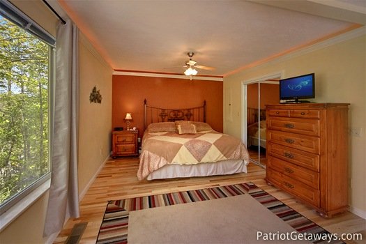 King bed with TV on chest of drawers at Quality Time, a 1 bedroom cabin rental located in Gatlinburg