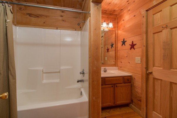 Bathroom with a tub and shower at Denim Blues, a 1-bedroom cabin rental located in Gatlinburg