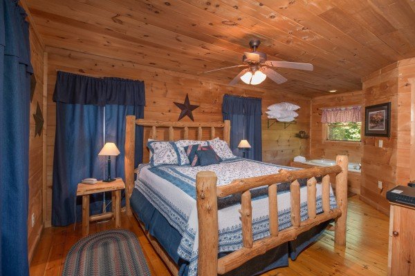 Bedroom with a log bed, tables, and lamps at Denim Blues, a 1-bedroom cabin rental located in Gatlinburg