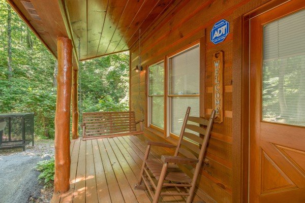 Porch with a swing and rocking chair at Denim Blues, a 1-bedroom cabin rental located in Gatlinburg