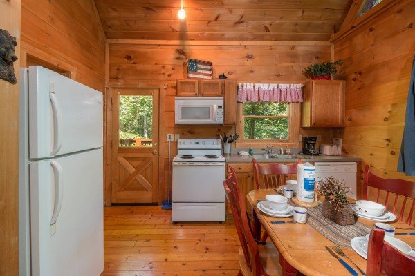 Kitchen with white appliances at Denim Blues, a 1-bedroom cabin rental located in Gatlinburg