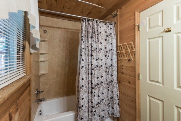 Bathroom with a tub and shower at Living on Love, a 2 bedroom cabin rental located in Pigeon Forge