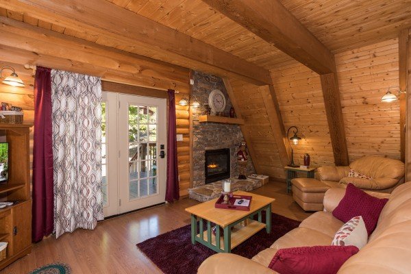 Deck access and fireplace in the living room at Living on Love, a 2 bedroom cabin rental located in Pigeon Forge