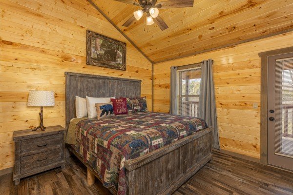 Bedroom with a night stand, lamp, and deck access at Everly's Splash, a 4 bedroom cabin rental located in Pigeon Forge