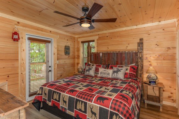 Bedroom with a king bed and deck access at Sawmill Springs, a 3 bedroom cabin rental located in Pigeon Forge
