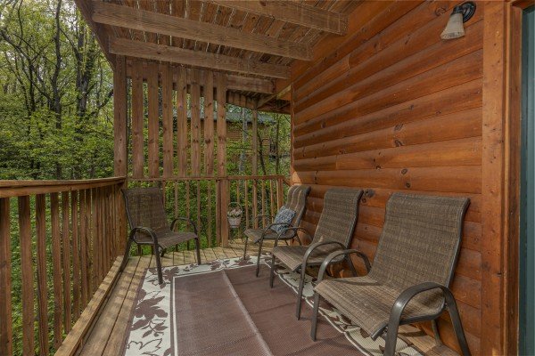 Chairs on a covered deck at A Moment in Time, a 2 bedroom cabin rental located in Pigeon Forge
