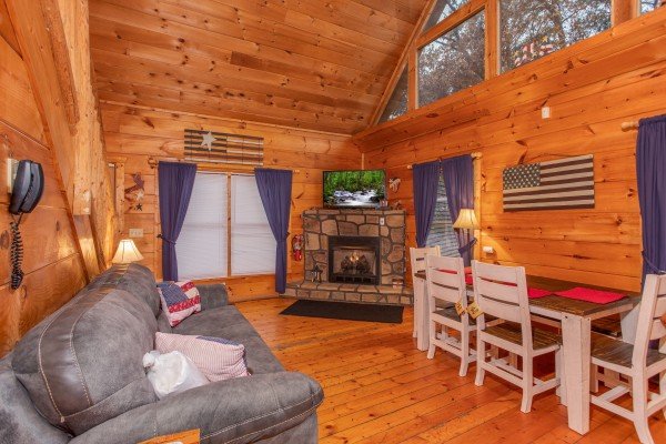 Fireplace, TV, and dining table in the living room at Patriot Inn, a 1 bedroom Gatlinburg cabin rental