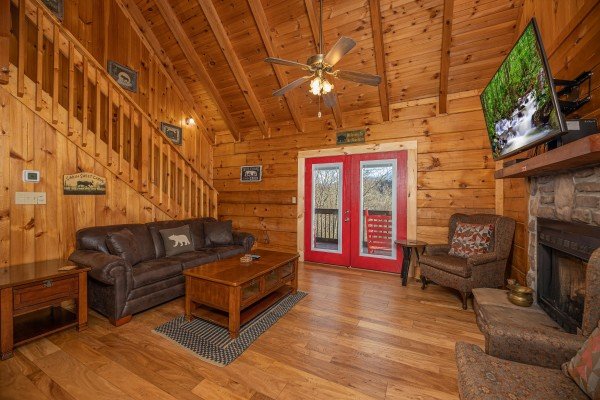 Living room with sofa, TV, fireplace, and deck access at Wonders in the Sky, a 3 bedroom cabin rental located in Gatlinburg