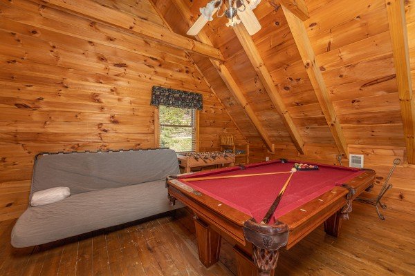 Pool table and futon at American Beauty, a 2 bedroom cabin rental located in Pigeon Forge