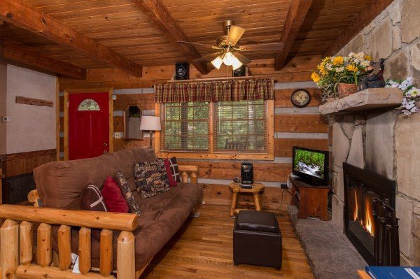 Futon in the living room at Little Bear, a 1 bedroom cabin rental located in Pigeon Forge