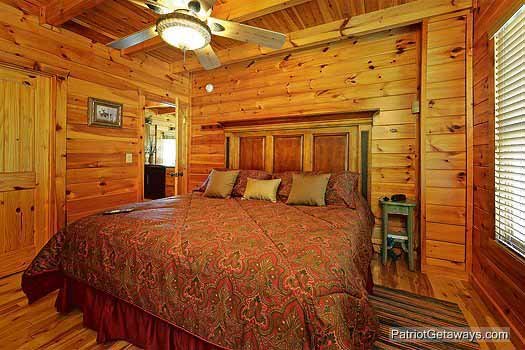 Main floor bedroom with king sized bed at Logged Out, a 3 bedroom cabin rental located in Pigeon Forge