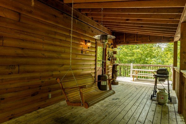 Covered patio swing at Hooked on Cowboys Lodge, a 2 bedroom cabin rental located in Pigeon Forge