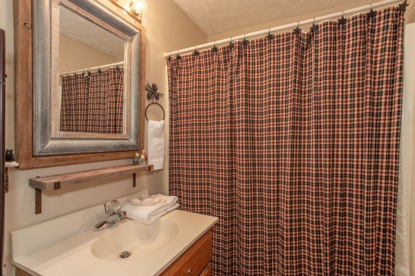 Bathroom with a tub and shower at Black Bear Holler, a cabin rental in Pigeon Forge