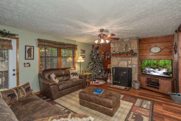 Living room with fireplace and TV at Black Bear Holler, a cabin rental in Pigeon Forge