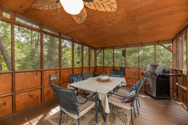 Dining for six with a propane grill on a screened in deck at Black Bear Holler, a 2 bedroom cabin rental located in Pigeon Forge