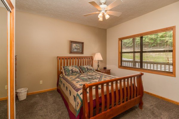 Bedroom with a night stand and lamp at Stones Throw, a 4 bedroom cabin rental located in Pigeon Forge