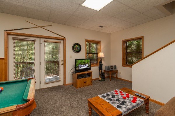 Pool table, checkers, and a TV in the lower living room at Stones Throw, a 4 bedroom cabin rental located in Pigeon Forge