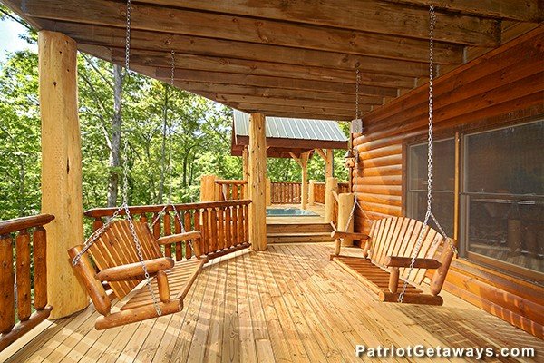 Two porch swings on the covered deck at Incredible! A 6 bedroom cabin rental located in Gatlinburg