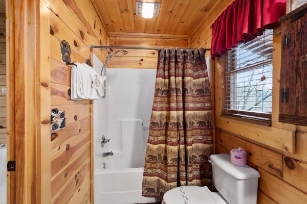 Bathroom with a tub and shower at Bootlegger's Bounty, a 1-bedroom cabin rental located in Pigeon Forge