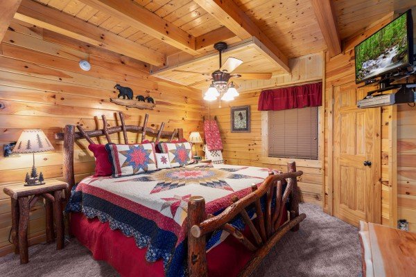 Bedroom with a log bed and TV at Bootlegger's Bounty, a 1-bedroom cabin rental located in Pigeon Forge