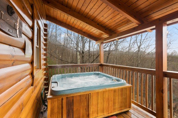 Hot tub on a covered deck at Bootlegger's Bounty, a 1-bedroom cabin rental located in Pigeon Forge