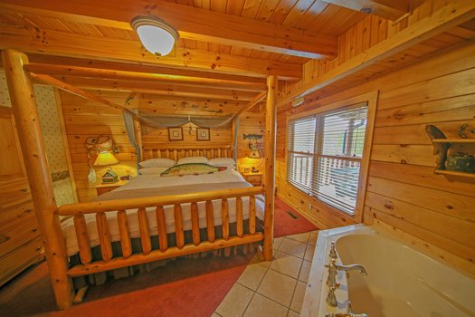 Bedroom with a king-sized canopy bed at Fox n' Socks, a 3-bedroom cabin rental located in Pigeon Forge