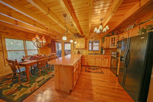 Kitchen with black appliances and dining space at Fox n' Socks, a 3-bedroom cabin rental located in Pigeon Forge