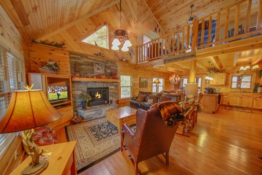 Living room with TV, fireplace, and vaulted ceiling at Fox n' Socks, a 3-bedroom cabin rental located in Pigeon Forge