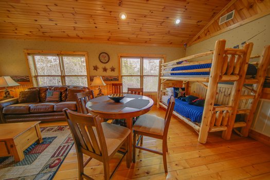 Living room with twin bunk bed and table for four at Fox n' Socks, a 3-bedroom cabin rental located in Pigeon Forge