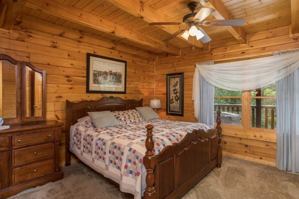 Bedroom with a king bed, dresser, and night stand at Laid Back, a 2 bedroom cabin rental located in Pigeon Forge