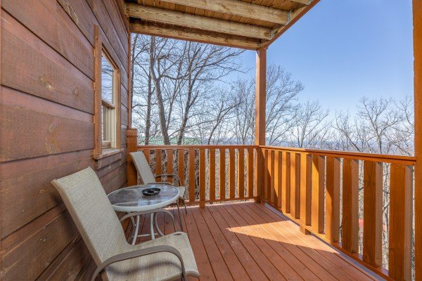 Covered deck with two chairs and a table at Tip Top View, a 3 bedroom cabin rental located in Pigeon Forge