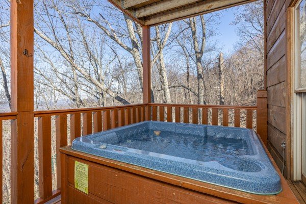 Hot tub on a covered deck at Tip Top View, a 3 bedroom cabin rental located in Pigeon Forge