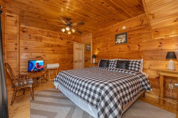 King bed, night stands, chair, and TV in a bedroom at Tip Top View, a 3 bedroom cabin rental located in Pigeon Forge
