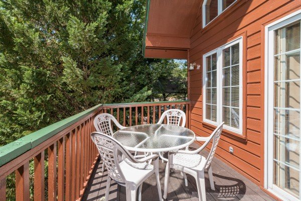 Table for four on the deck at Ain't Misbehaven, a 1 bedroom cabin rental located in Pigeon Forge