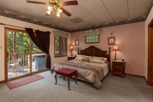 King bed and deck access in a bedroom at Ain't Misbehaven, a 1 bedroom cabin rental located in Pigeon Forge