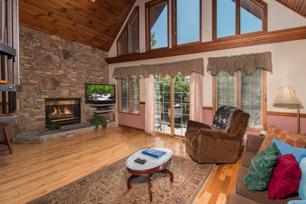 Living room with fireplace and TV at Ain't Misbehaven, a 1 bedroom cabin rental located in Pigeon Forge