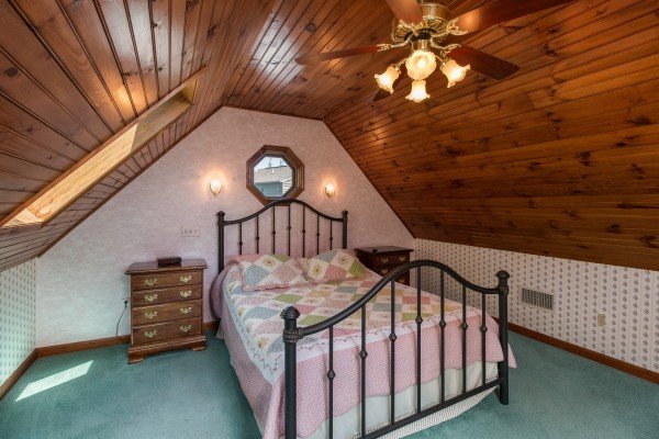 Bed and night stands in a bedroom at Ain't Misbehaven, a 1 bedroom cabin rental located in Pigeon Forge