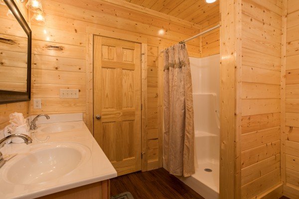 Double vanity sinks in a bathroom with a shower at Splash Mountain Lodge a 4 bedroom cabin rental located in Gatlinburg